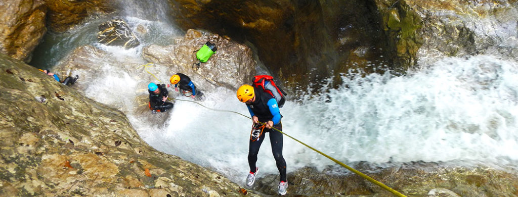 Canyoning abseilen in der Schlucht mit Wasserfall Level 3 Sicherheit