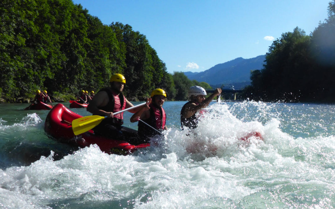 Wildwasser Rafting im Allgäu auf der Iller mit spritzenden Wellen im Canadier Boot